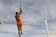 © moodboard - Low angle view of a male athlete performing a pole vault against the sky
