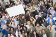 © moodboard - High angle view of man raising billboard in rally with people supporting around him