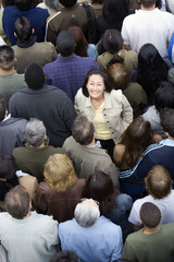 Portrait of happy Asian Chinese woman standing amidst around the people