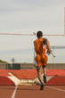 © moodboard - Rear view of male pole vaulter running with pole