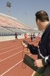 © MDBPIXS - Male with stopwatch looking at athletes racing in stadium