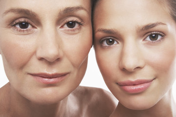 closeup portrait of two beautiful women smiling on white background