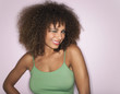 © MDBPIXS - Portrait of an afro woman with curly hair winking against pink background