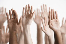 Closeup Of Multiethnic Men And Women Raising Hands Against White Background