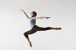 © moodboard - Full length of female ballet dancer leaping in mid air isolated on white background