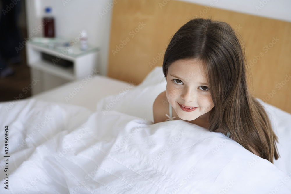 Portrait of happy little girl sitting in bed Stock Photo | Adobe Stock