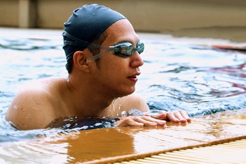 Swimmer is resting in the pool.