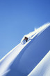 Man skiing on steep slope against clear blue sky