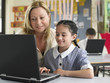 © MDBPIXS - Teacher and schoolgirl using laptop in classroom