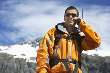 Smart Smiling Man Using Walkie Talkie Against Blurred Snow Capped Mountain