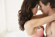 Side view of passionate young couple embracing in bedroom