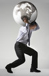 Full length side view of a businessman struggling to carry globe on shoulders against gray background