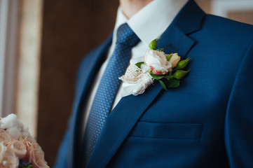 the groom in a blue suit with  tie