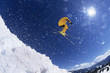 Low angle view of a skier in midair above snow on ski slopes