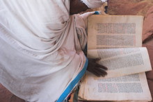 Pilgrim Reading Religious Book On Church Steps, Lalibela, Ethiopia