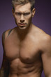 © MDBPIXS - Portrait of a shirtless man isolated over purple background