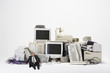 Digital composite of businessman sitting by various obsolete technologies against white background