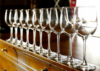 Poster - Row of empty wine glasses on bar counter