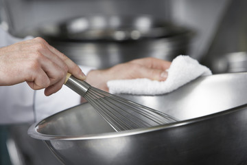 Wall Mural - Closeup of hands mixing ingredients in a bowl