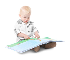 Wall Mural - Baby boy with book sitting on white background