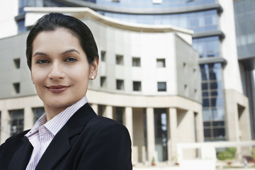 Wall Mural - Closeup portrait of beautiful young businesswoman in front of buildings