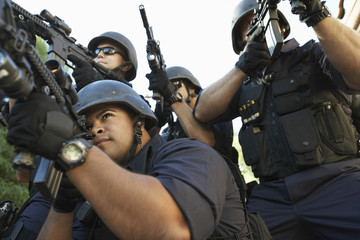 Group of police officers aiming with guns