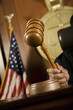 Closeup of a judge's hand striking the gavel in courtroom