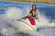 Portrait of a young couple enjoying personal watercraft ride on lake
