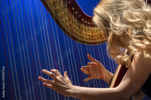 Fotografía Closeup portrait of young girl playing the harp during concert at musical theate