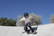 Teenage boy in skateboard park against blue sky
