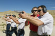 © MDBPIXS - Instructor assisting officers with hand guns at firing range during weapons training