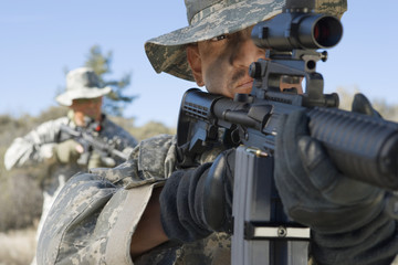 Wall Mural - US army soldiers aiming rifles in field