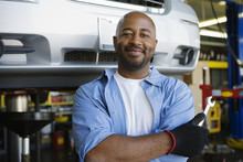 Portrait Of A Confident African American Male Mechanic Holding Wrench At Garage