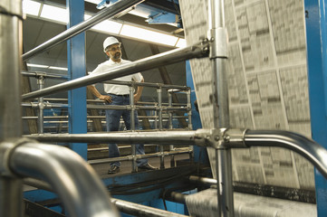 Full length of an Indian man working in newspaper factory