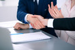 © rogerphoto - Business people shaking hands finishing up a meeting