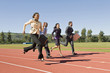 © MDBPIXS - Four multiethnic business people running together on racing track