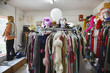 © moodboard - View of clothing and wigs in a crowded second hand store