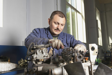 Mechanic working on motor in garage