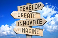Wooden Signpost With Four Arrows - Develop, Create, Innovate, Imagine.