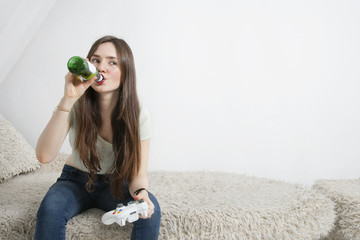 Wall Mural - Young woman drinking beer while playing video game