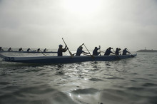 Group Of Multiethnic People Paddling Outrigger Canoes In Race