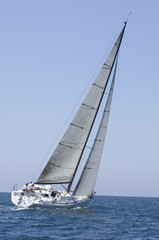 Poster - Sailboat racing in the blue and calm ocean against sky