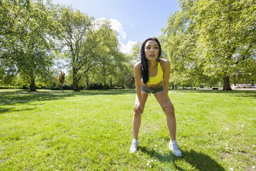 Wall Mural - Full length of tired fit woman taking a break while exercising in park