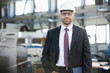 © MDBPIXS - Portrait of confident mid adult businessman wearing hardhat in metal industry