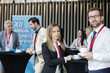 © MDBPIXS - Confident business people holding coffee cups at lobby in convention center