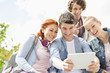 © MDBPIXS - Young friends photographing themselves through digital tablet at college campus