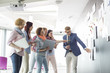 © MDBPIXS - Creative businesspeople discussing over documents on wall in office