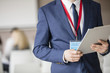© MDBPIXS - Midsection of businessman holding clipboard in seminar hall