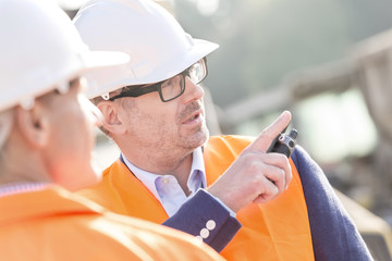 Wall Mural - Supervisor showing something to colleague at construction site