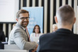 © MDBPIXS - Portrait of confident businessman sitting in seminar hall